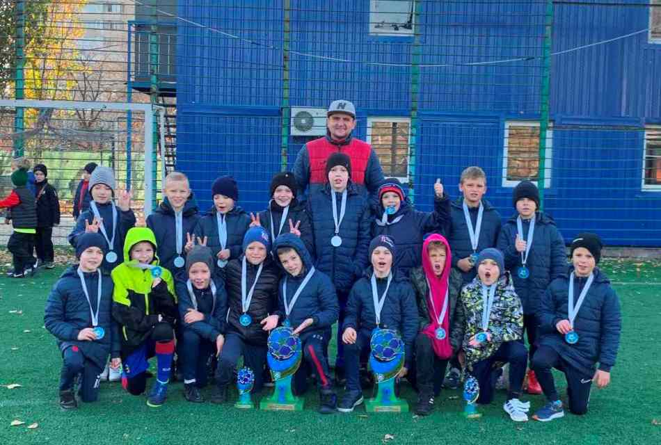 Group photo of the team with medals and cups after the awards ceremony